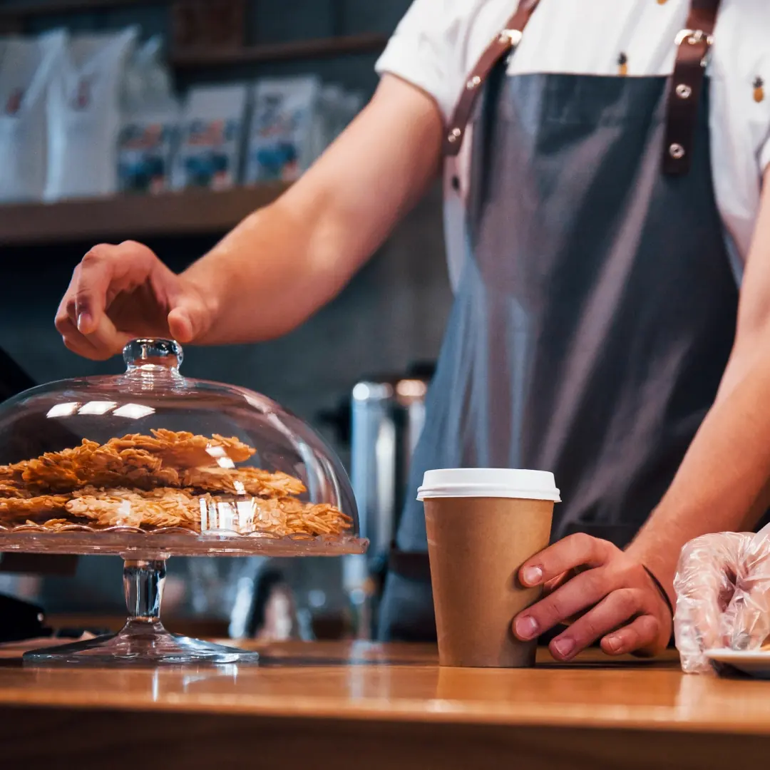 Barista tiskin takana, leivonnaiset kuvun alla